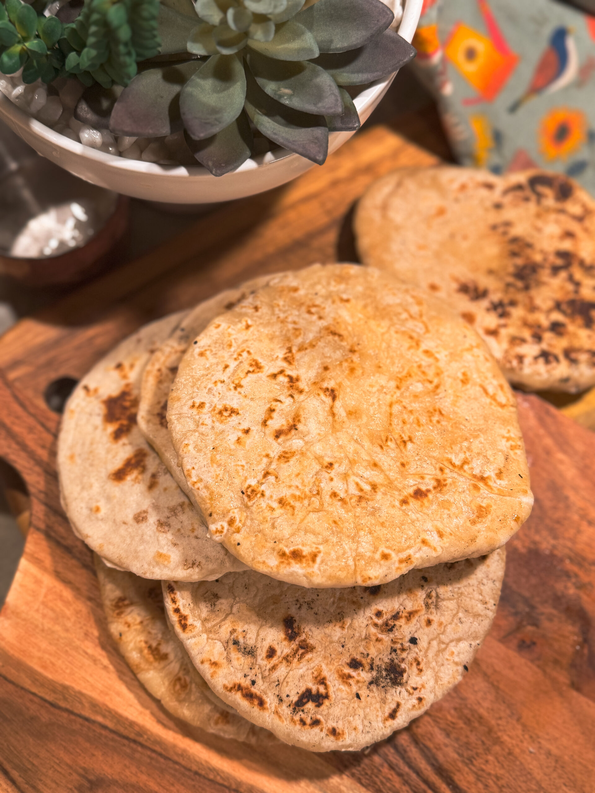 a stack of tortillas on a wooden board