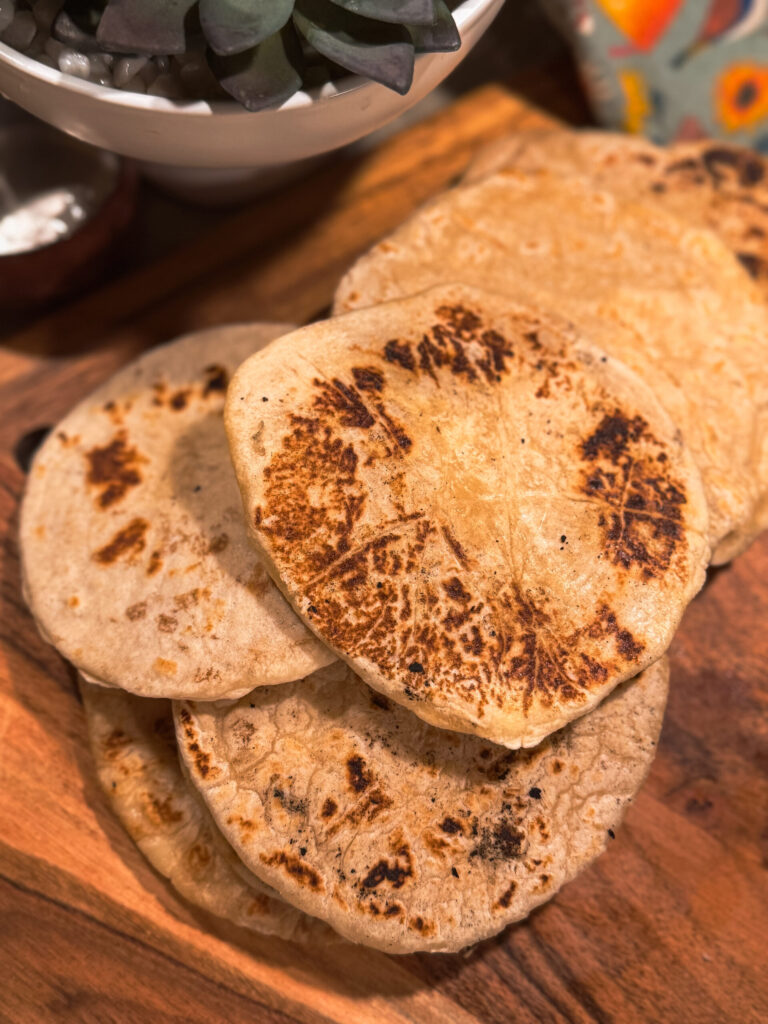 a stack of tortillas on a wooden board