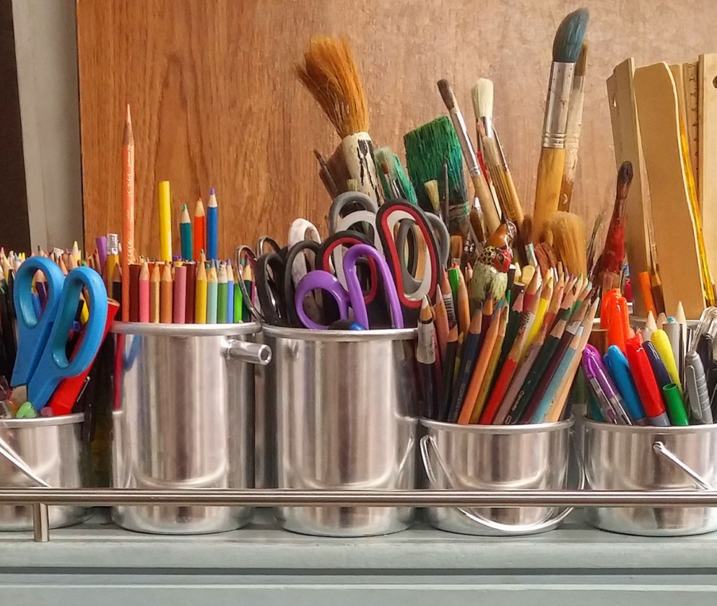a group of pencils and scissors in a row