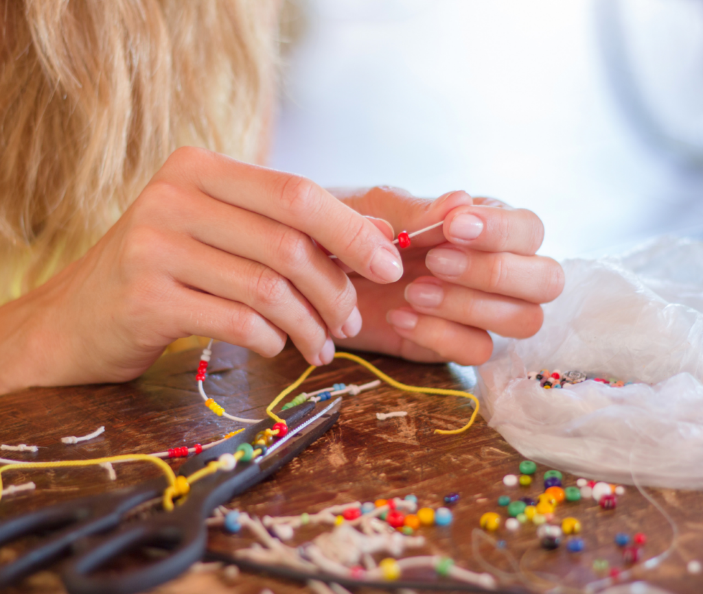 a person sewing beads on a table