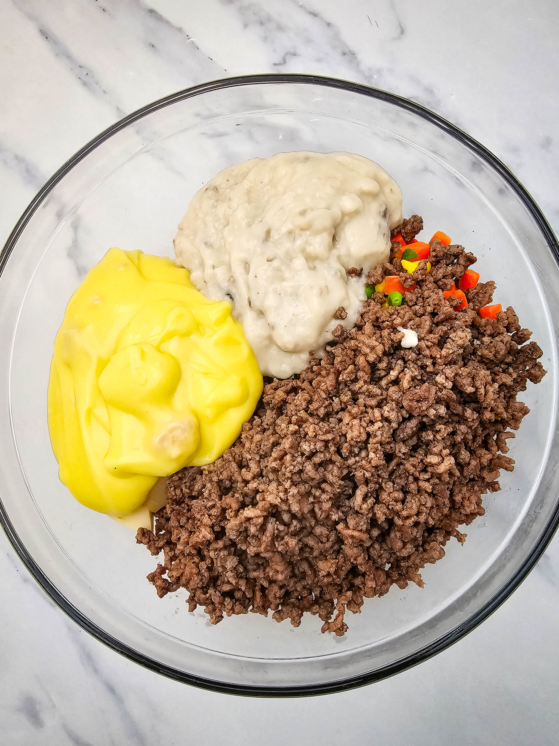 Cream of chicken soup and cream of mushroom soup added to the ground beef and vegetable mixture for Hobo Casserole.